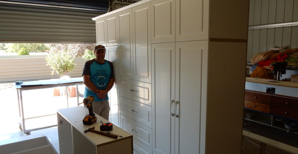 John from John's Cabinets with completed wall-to-wall wardrobe unit.